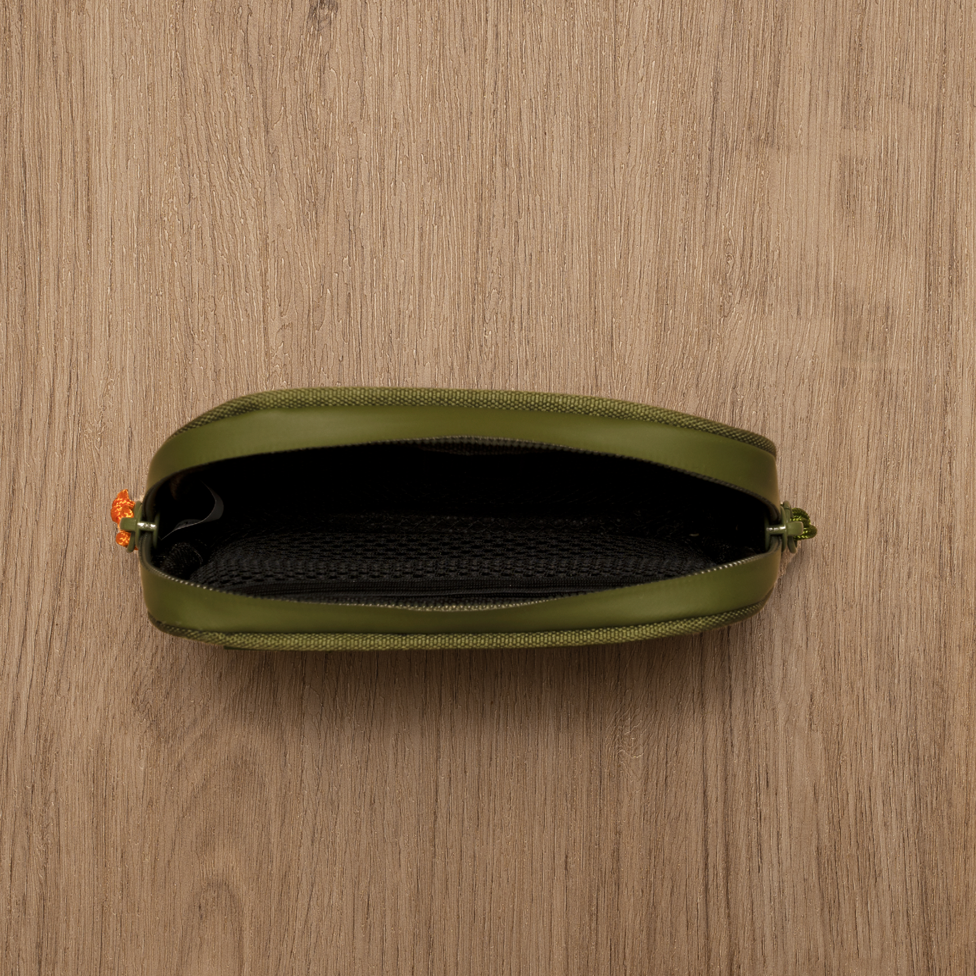 Green pouch with a zipper on a wooden surface