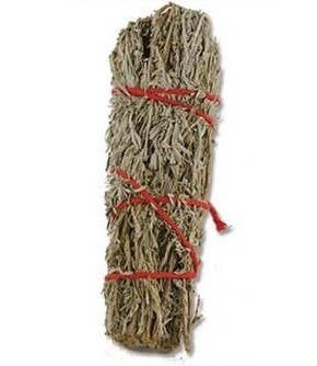 Bundled sage sticks tied with red string on a beige background