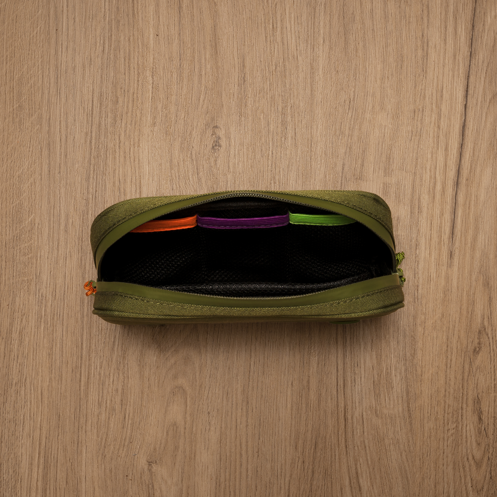 Green pouch with colorful items on a wooden surface