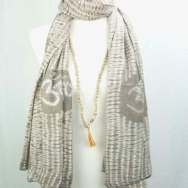 Gray patterned scarf with a necklace on a white background
