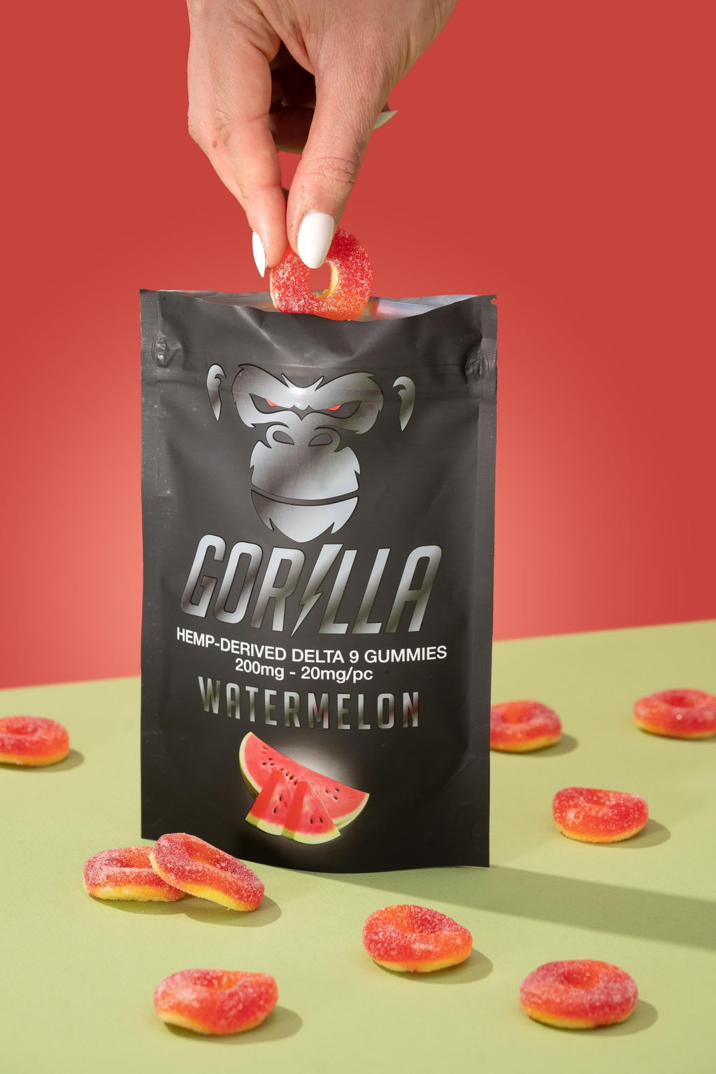 Gorilla brand watermelon gummies with packaging on a red and green background