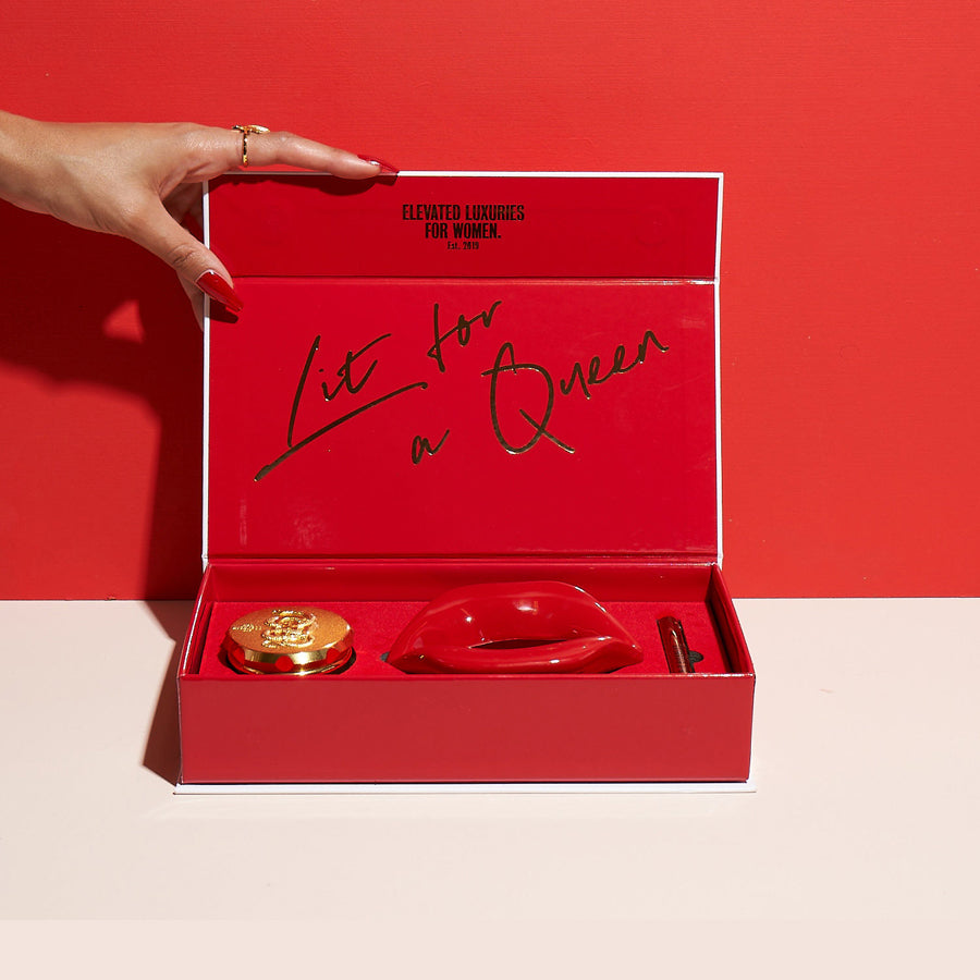 Red gift box with 'Lit for a Queen' text, held by a hand against a red background.