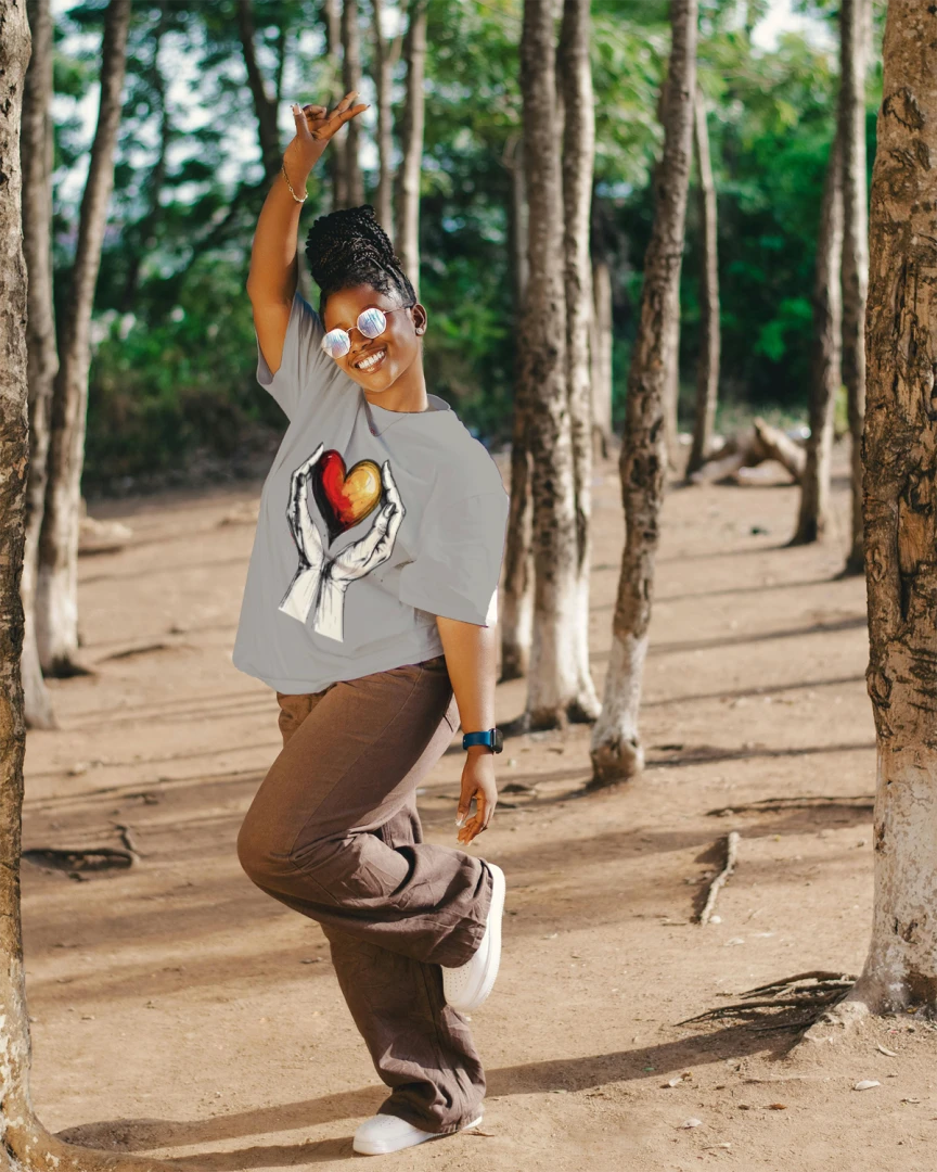 Person dancing in a forested area with trees and dirt path in the background