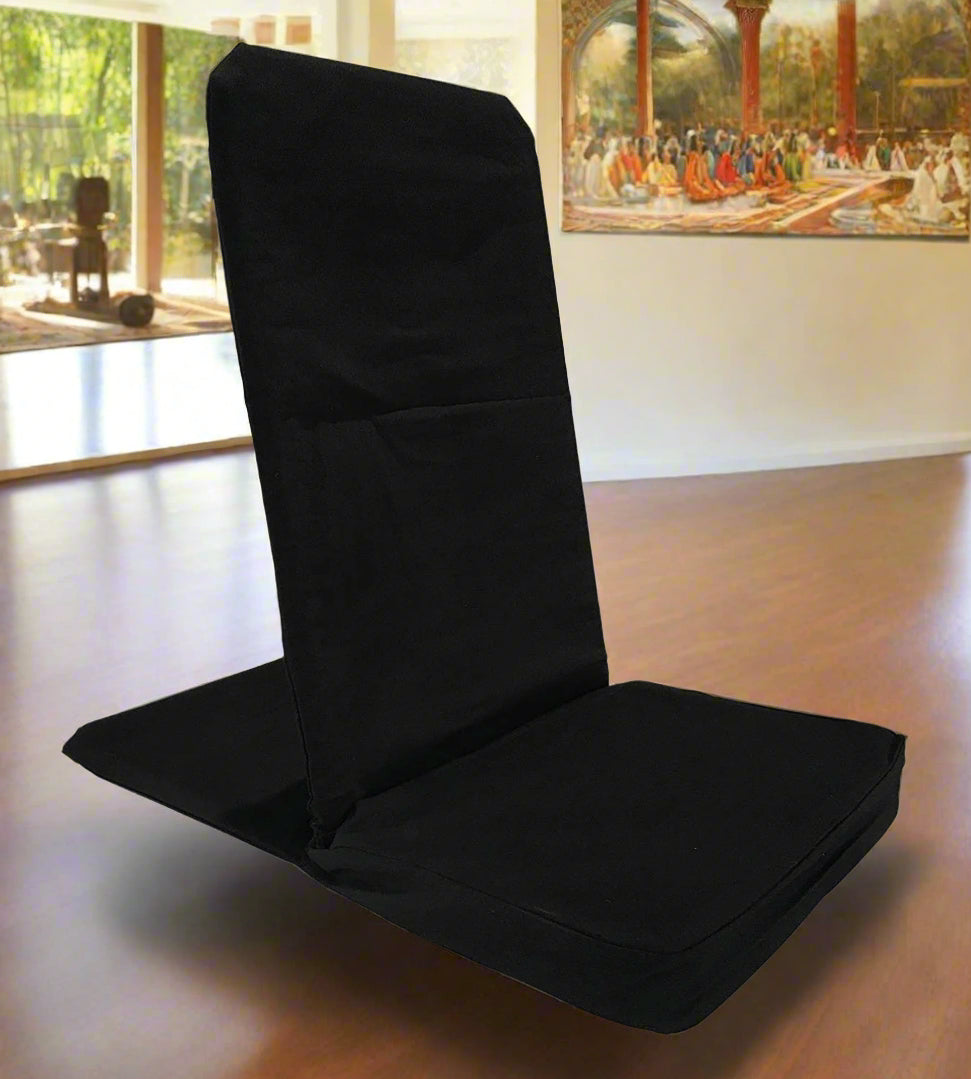 Black folding chair in a room with large windows and a painting on the wall.