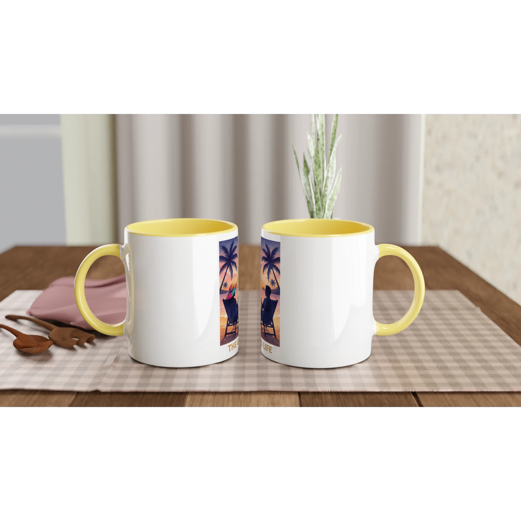 Two mugs with yellow interior and rim on a wooden table with a checkered tablecloth.