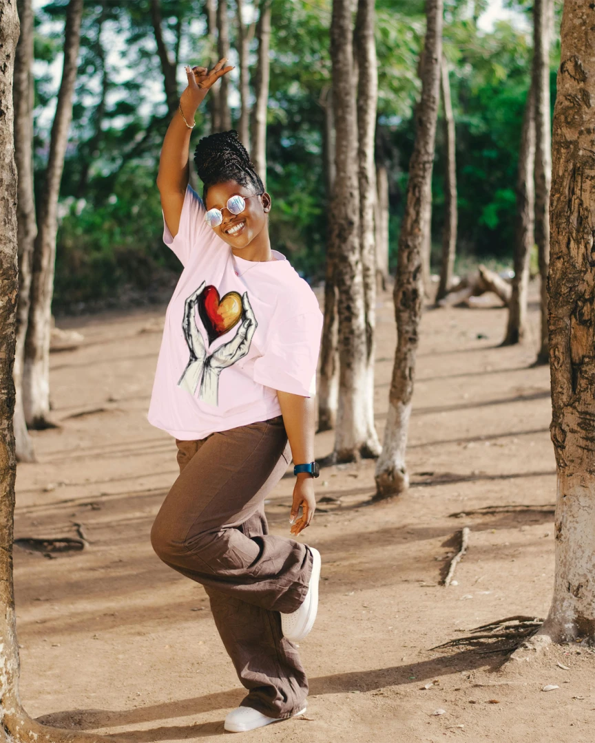 Person in a pink shirt with a heart design in a forest setting