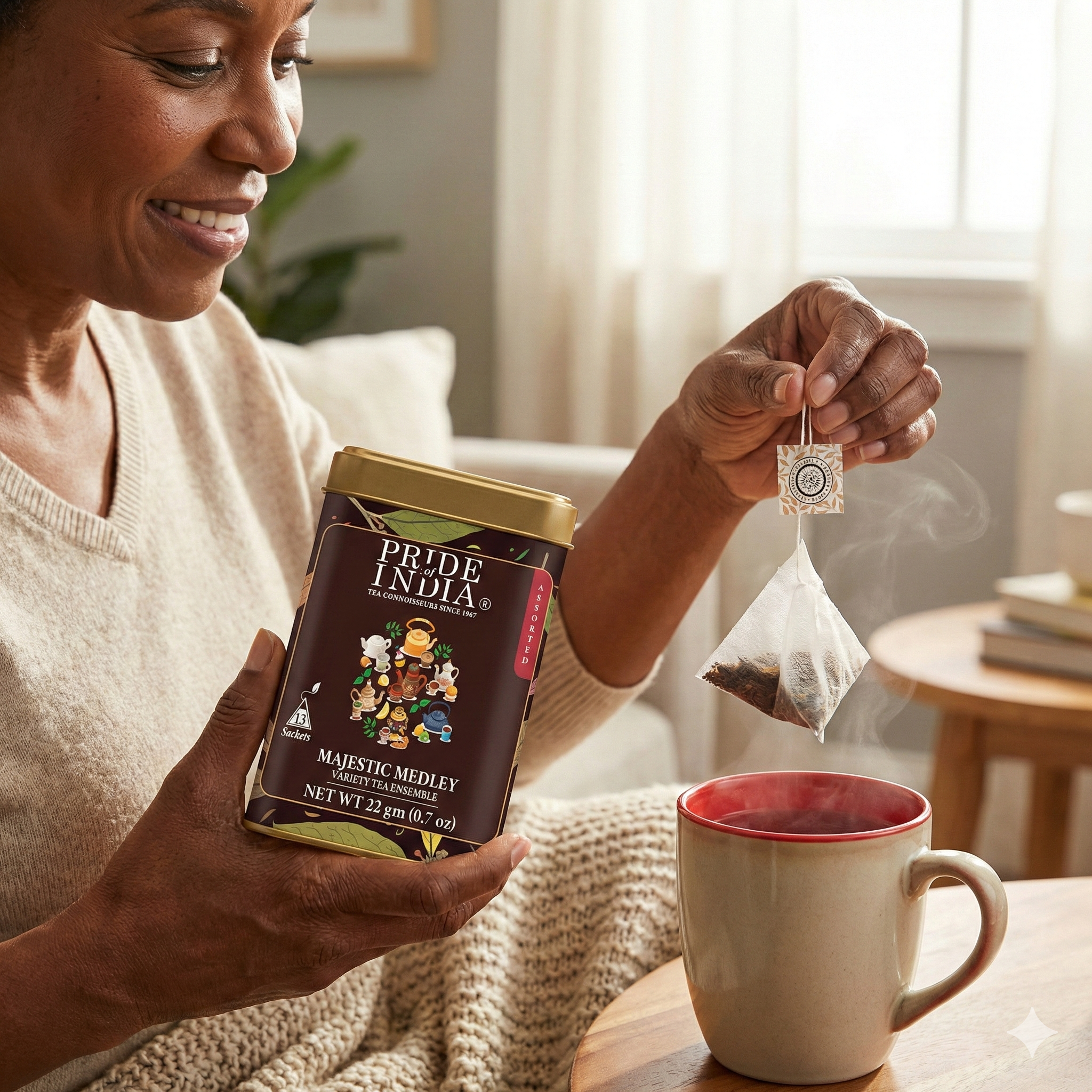 Woman holding a box of 'Pride of India' tea and a steaming cup of tea.