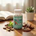 Bottle of Micro Dose Reishi capsules on a wooden surface with mushrooms and an open book in the background.