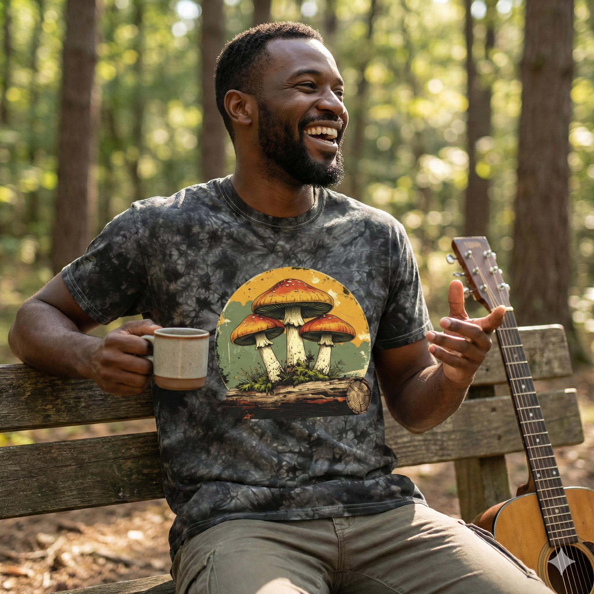 Man sitting on a bench in a forest, holding a mug and a guitar, wearing a t-shirt with a mushroom design.