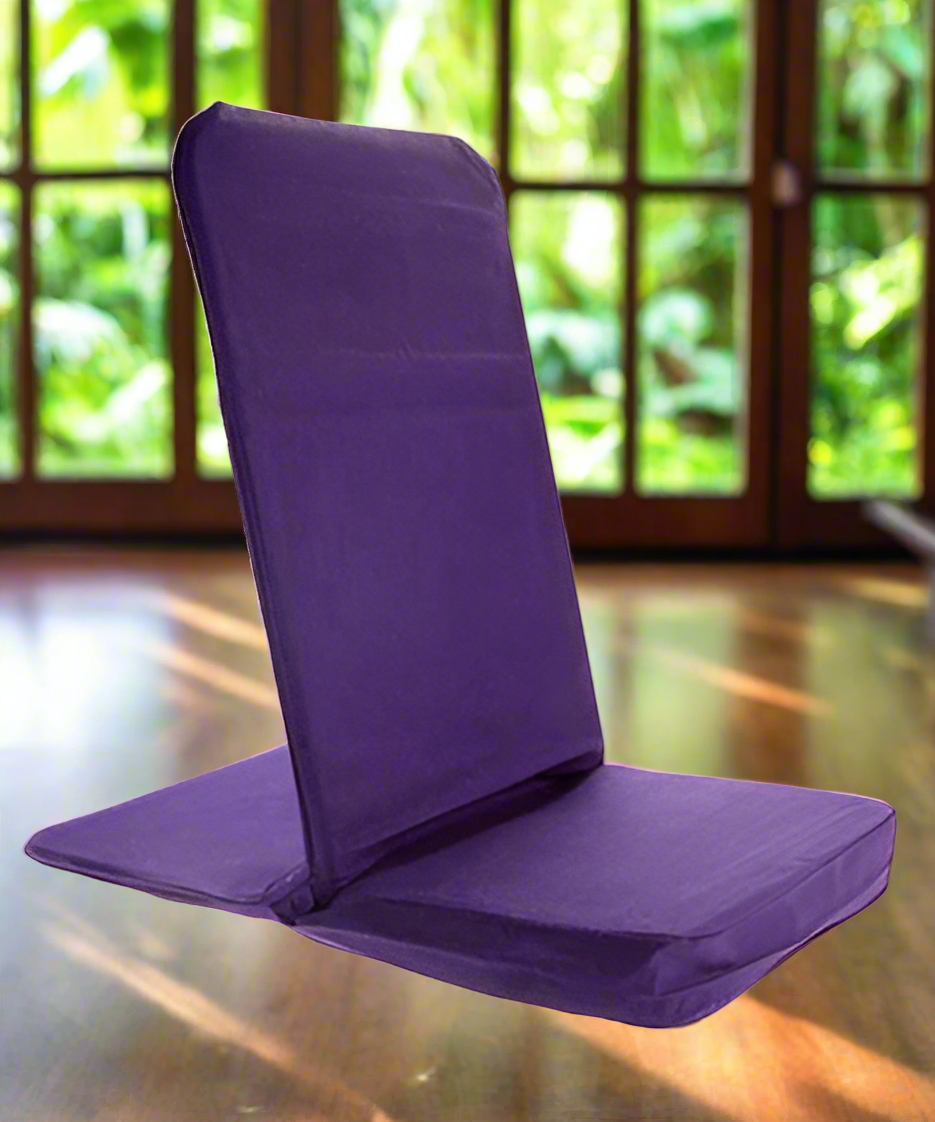 Purple folding chair on a wooden floor with a blurred green outdoor background