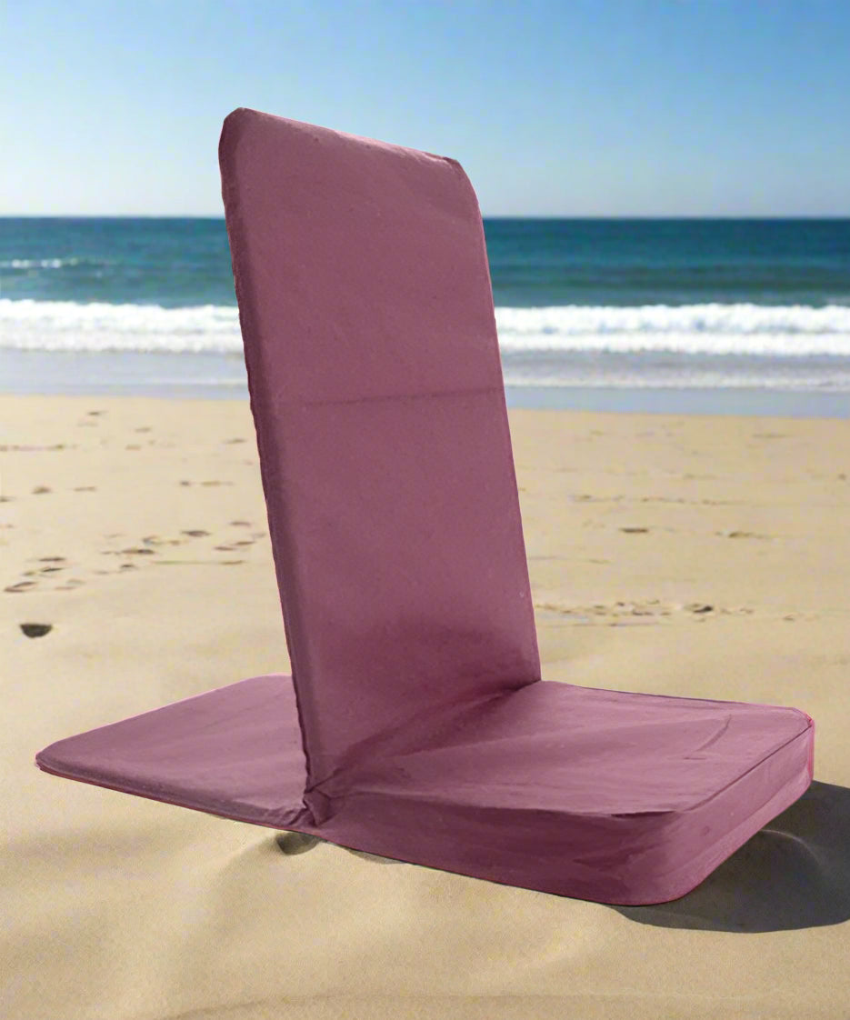 Purple beach chair on a sandy beach with ocean waves in the background