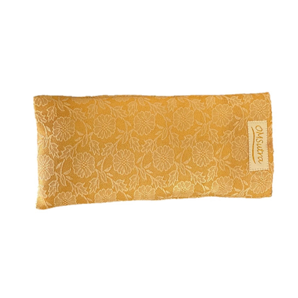 Yellow floral patterned eye pillow with a brand label on a white background