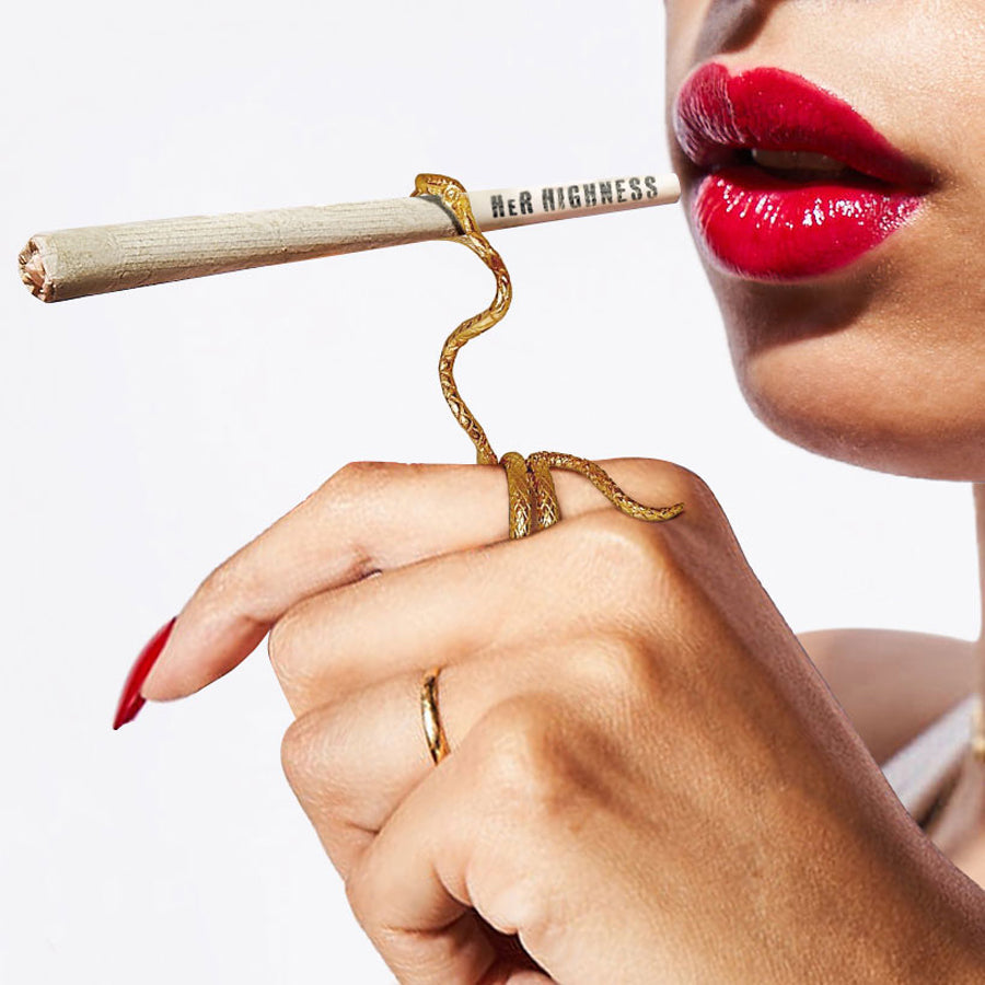 Close-up of a hand holding a pen with a gold cap, close to a person's red-lipped mouth.