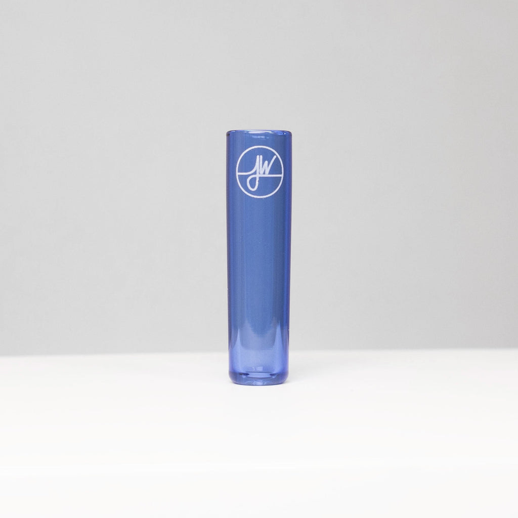 Blue cylindrical glass vase with a logo on a light gray background