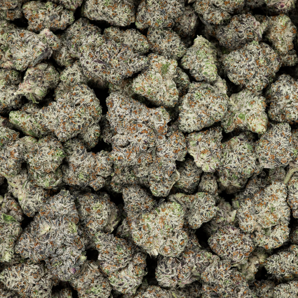 Close-up of a pile of cannabis buds with green and brown colors.