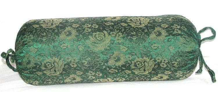 Green patterned cylindrical pillow on a white background