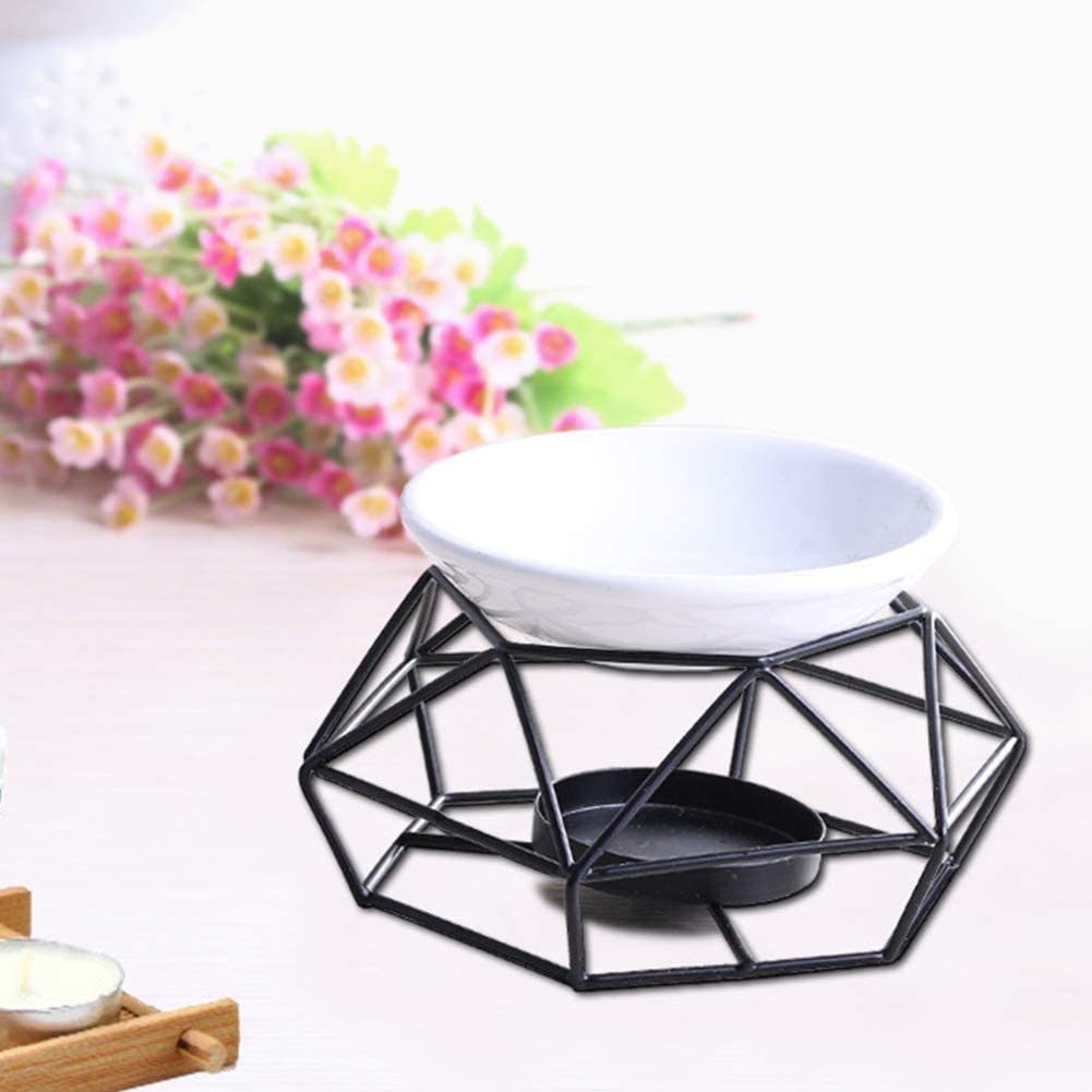 Black geometric candle holder with white bowl on a light surface with flowers in the background