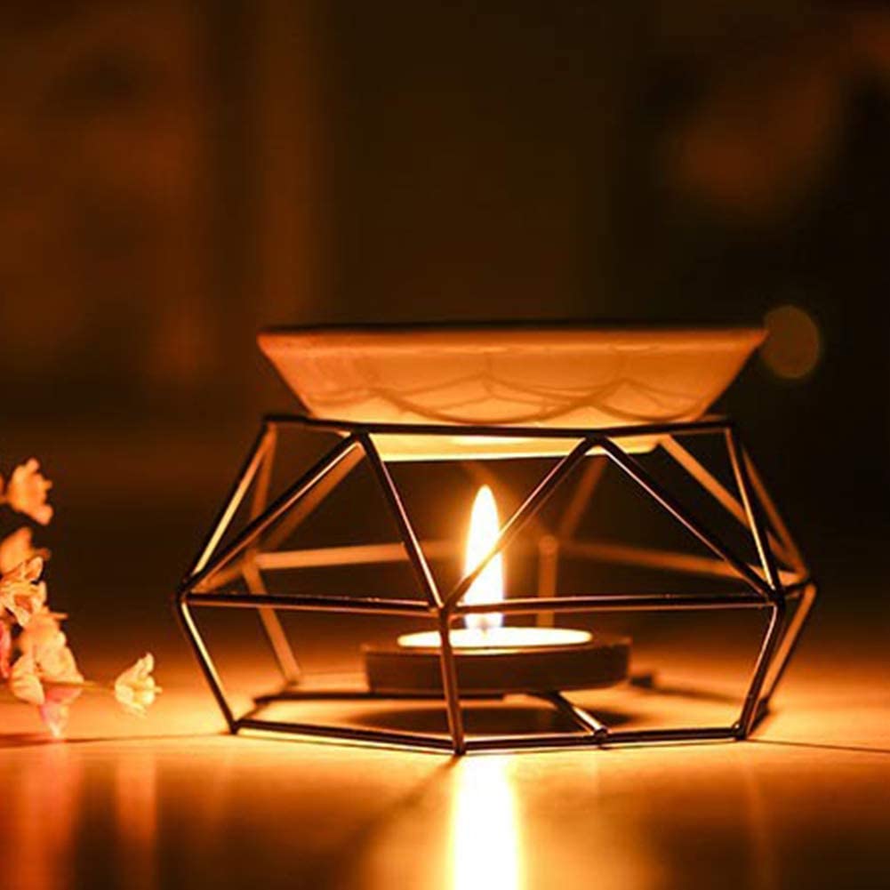 Geometric candle holder with a lit candle on a dark background