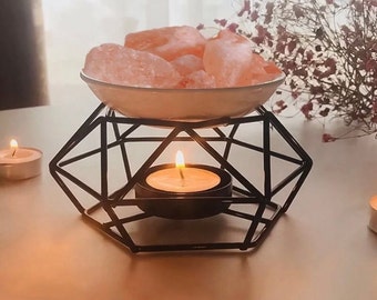 Himalayan salt lamp with geometric metal stand on a table
